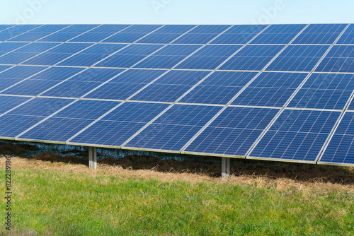 Blue solar cells in a solar panels power farm or photovoltaic cell park in a green field. Green Energy Concept 