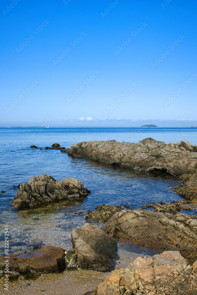 ゴツゴツした岩の潮溜りの透き通った青い海