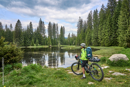 active senior woman on a bike packing tour with her electric mountain bike in the Bavarian Forest National Park, Bavaria, Germany