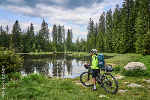 active senior woman on a bike packing tour with her electric mountain bike in the Bavarian Forest National Park, Bavaria, Germany