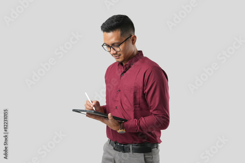 A handsome young Asian man in a suit wears glasses and makes various facial expressions while using a tablet