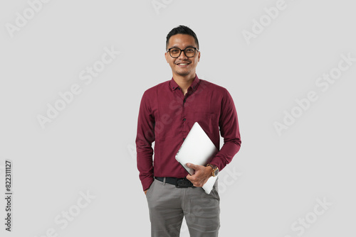 A young handsome Asian man in a suit wearing glasses and making various facial expressions and holding a laptop.