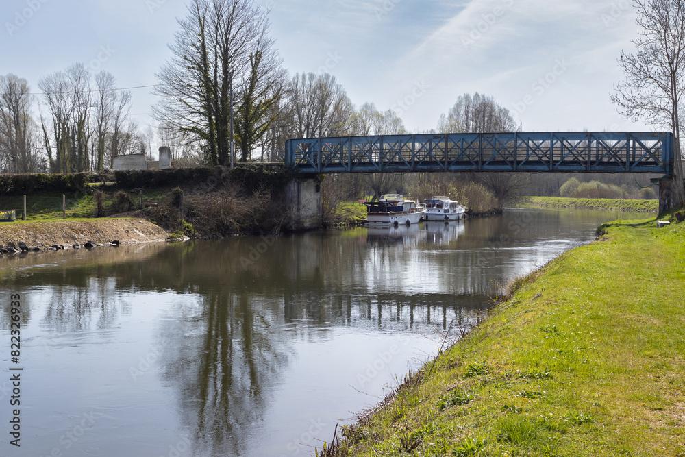 Spring view of Eaucourt-sur-Somme bridge near Abbeville, and the River Somme as it flows through the commune of Eaucourt-sur-Somme in the Somme department of Hauts-de-France in northern France.