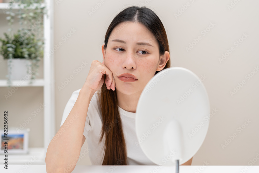 Dermatology, expression face worry asian young woman looking mirror hand touch face at dark spot of melasma, freckle from pigment melanin, allergy sun. Beauty care, skin problem treatment, acne care. Dermatology, expression face worry asian young woman looking mirror hand touch face at dark spot of melasma, freckle from pigment melanin, allergy sun. Beauty care, skin problem treatment, acne care.