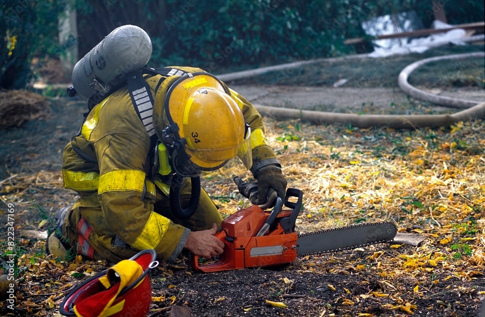 Fototapeta premium Fireman Starting Chainsaw