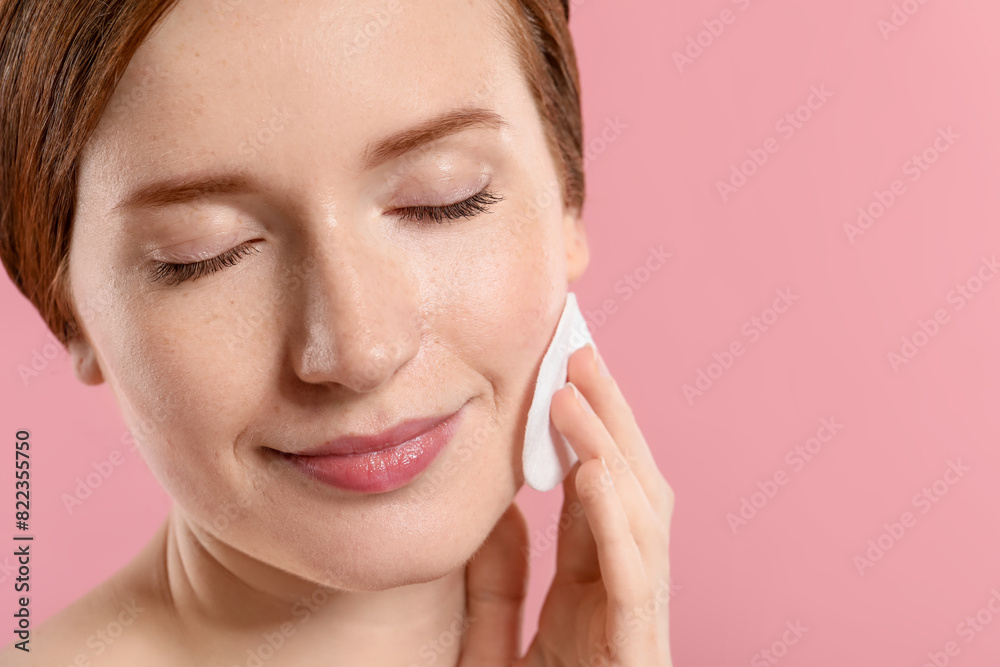 Beautiful woman with freckles wiping face on pink background, closeup. Space for text Beautiful woman with freckles wiping face on pink background, closeup. Space for text