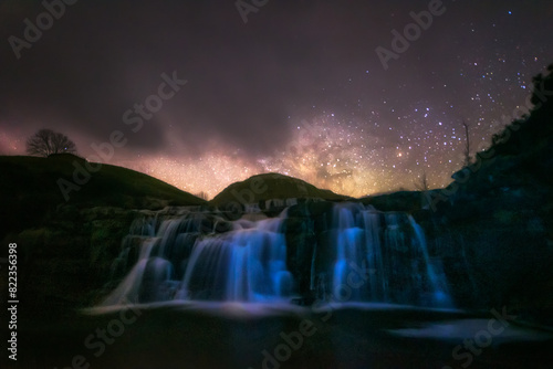 Milky Way over the Guarguero waterfall, in the Estacas de Trueba mountain pass, Burgos, with a partly cloudy sky