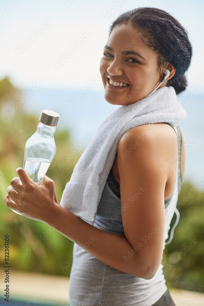 Woman, portrait or water with headphones in nature for exercise, listening or streaming for workout. Female runner, natural smile or bottle for training by ocean, trail running in Brazil for wellness Woman, portrait or water with headphones in nature for exercise, listening or streaming for workout. Female runner, natural smile or bottle for training by ocean, trail running in Brazil for wellness