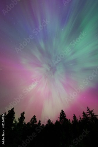 Aurora Borealis rays spreading from auroral corona point creating night sky filled with pastel colors of northern lights