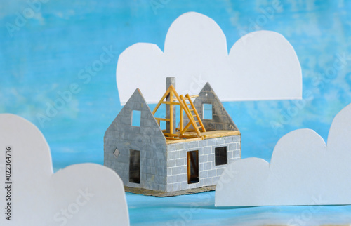 the dream of home ownership, model house under construction and clouds, conceptual image, shallow depth of field
