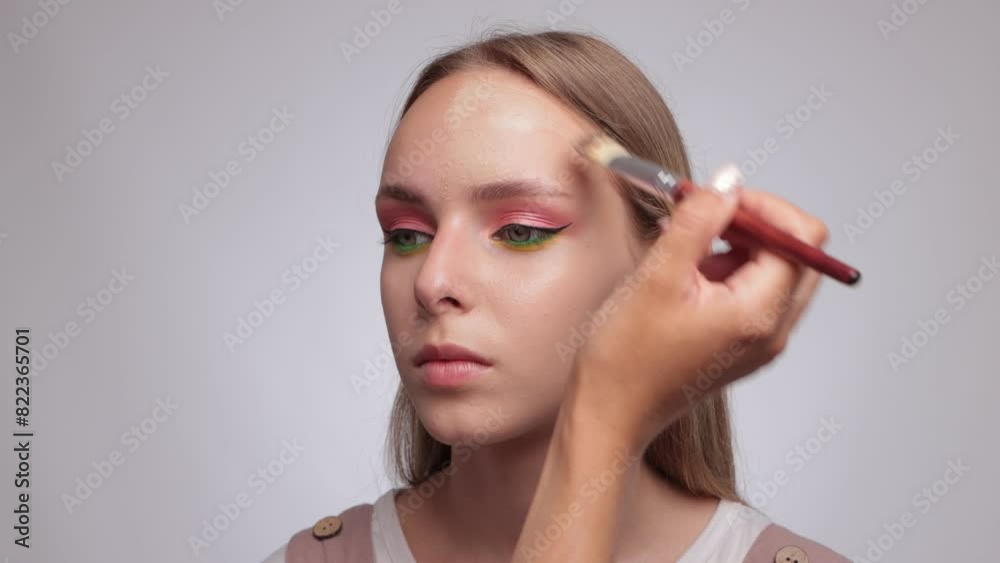 Makeup artist applies foundation on the face of a beautiful girl. Professional makeup concept Makeup artist applies foundation on the face of a beautiful girl. Professional makeup concept