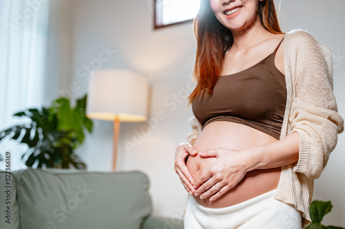 mother, happiness, pregnancy, family, abdomen, motherhood, happy, parenthood, pregnant, prenatal. A woman is holding her stomach and making a heart shape with her fingers. She is smiling and happy. Free Download mother, happiness, pregnancy, family, abdomen, motherhood, happy, parenthood, pregnant, prenatal. A woman is holding her stomach and making a heart shape with her fingers. She is smiling and happy. - GFXLoad