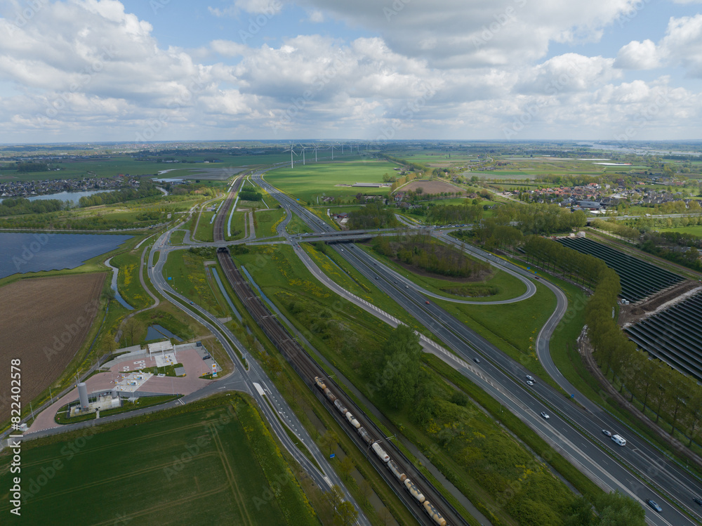 Fototapeta premium Transportation and mobility on the infrastructure of The Netherlands. Crossing of roads highways, asphalt road and green landscape. The Netherlands. Aerial drone view.