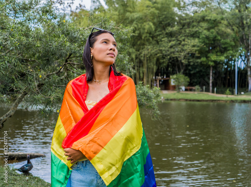 mujer hispano latina en el parque con la bandera del orgullo gay casual  photo