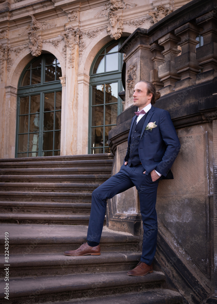 Groom on his wedding day. Stylish, elegant groom stands on the steps Groom on his wedding day. Stylish, elegant groom stands on the steps