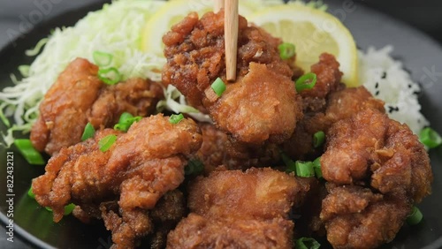 Eating Japanese Fried crispy Chicken Karaage in black bowl with rice and cabbage