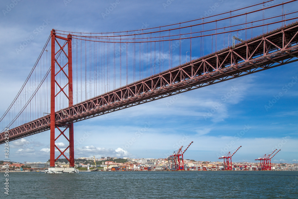 Obraz premium The 25th April Bridge, connecting the city of Lisbon, capital of Portugal, to the municipality of Almada over the Tagus River