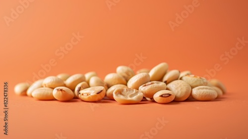Pile of white beans isolated on an orange background. Perfect for nutrition, healthy eating, and plant-based protein concepts.