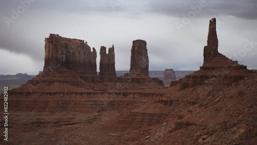 Aerial flyover view leaving Bear and Rabbit and King on his Throne rock formations / Monument Valley, Utah, United States