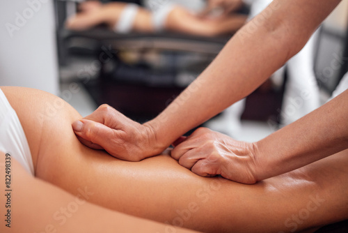 Masseuse makes anti cellulite massage of buttocks, thighs and legs to her client