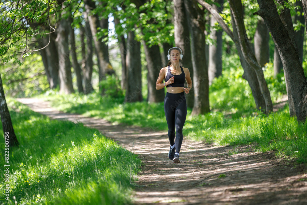 Young fitness woman jogging in park at sunny morning Young fitness woman jogging in park at sunny morning