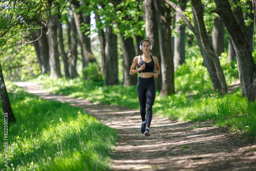 Young fitness woman jogging in park at sunny morning © skumer
