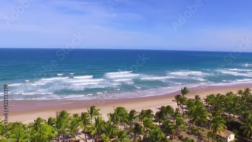 Drone levanta vôo entre coqueiros mostrando o mar em praia paradisíaca vazia no litoral da Bahia, Brasil. Filme aéreo de ondas quebrando no mar. photo