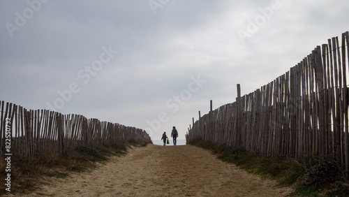 Silhouettes d'un adulte et d'un enfant se dirigeant vers la plage photo