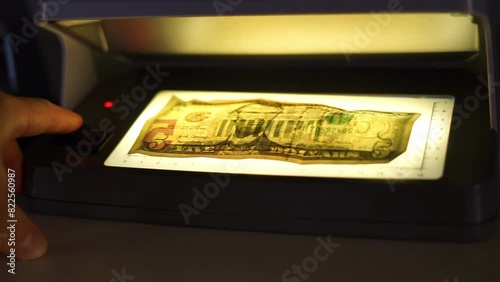 checking money for fakeness using light photo