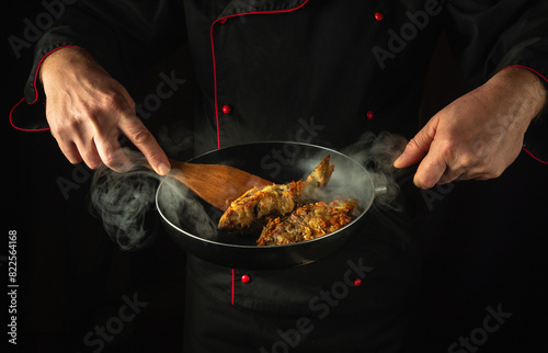 Preparing fried fish in a restaurant kitchen. Cook or fry rudd fish in a frying pan. Delicious fish dish idea photo