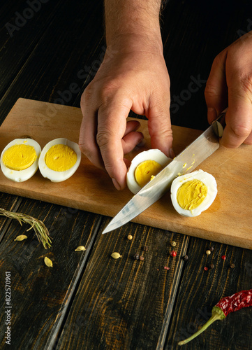 Egg diet concept. Cooking boiled eggs on the kitchen table. A knife in the hands of a cook