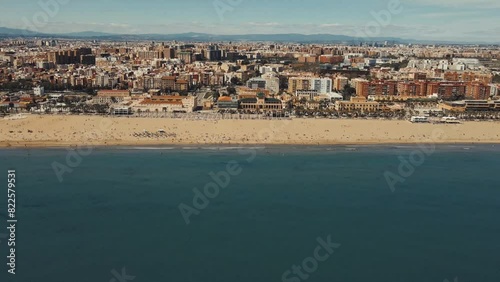 Aerial View of Bustling Coastal City and Expansive Beach on a Sunny Day