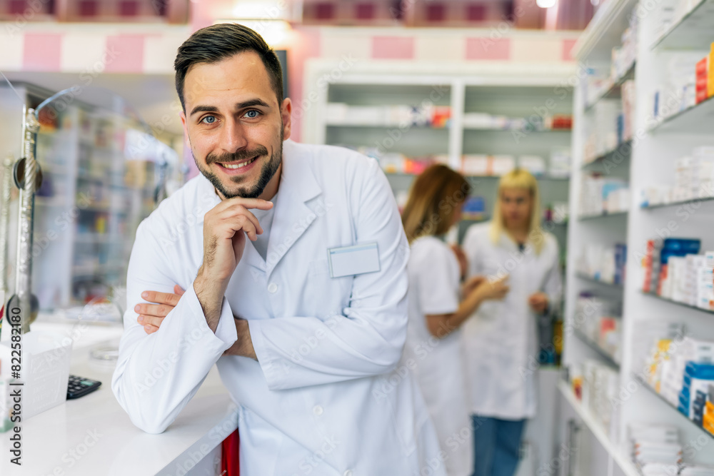 Smiling portrait of young handsome male pharmacist at the pharmacy, drugstore. Smiling portrait of young handsome male pharmacist at the pharmacy, drugstore.