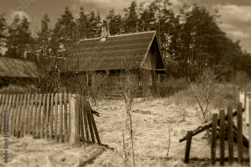 An old wooden house in a remote area and a crumbling fence