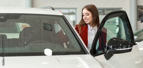 Woman choosing new car in s...