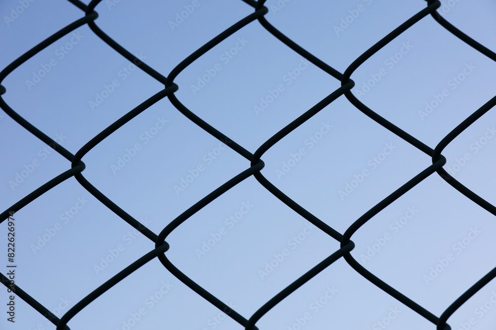 A wire fence silhouetted against a clear sky