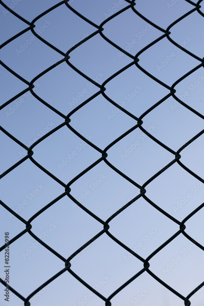 A wire fence silhouetted against a clear sky A wire fence silhouetted against a clear sky