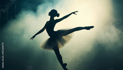 silhouette of a beautiful and talented ballerina woman in front of spotlights and smoke 