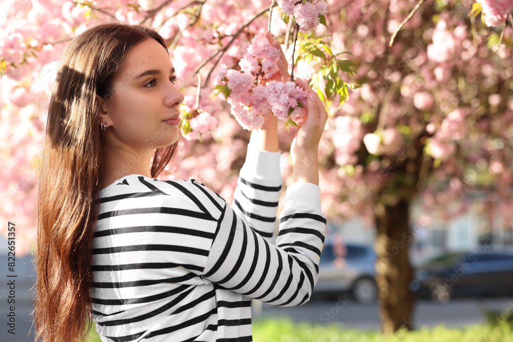 Beautiful woman near blossoming tree on spring day, space for text Beautiful woman near blossoming tree on spring day, space for text
