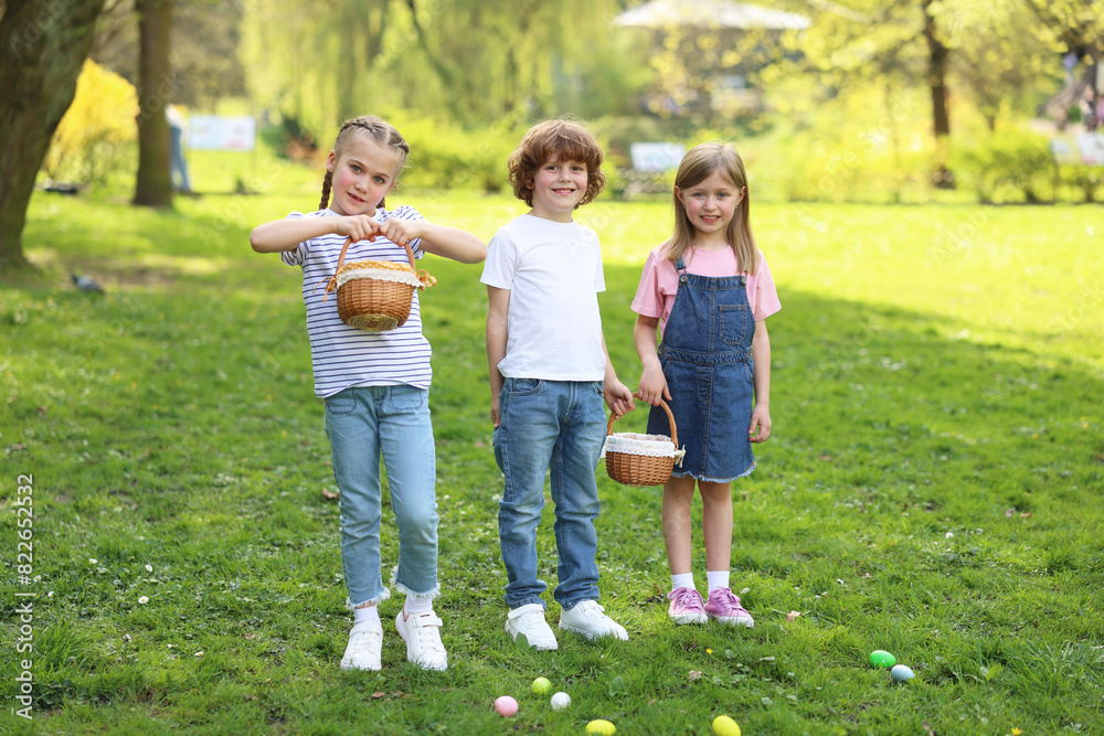 Easter celebration. Cute little children with wicker baskets and painted eggs outdoors Easter celebration. Cute little children with wicker baskets and painted eggs outdoors