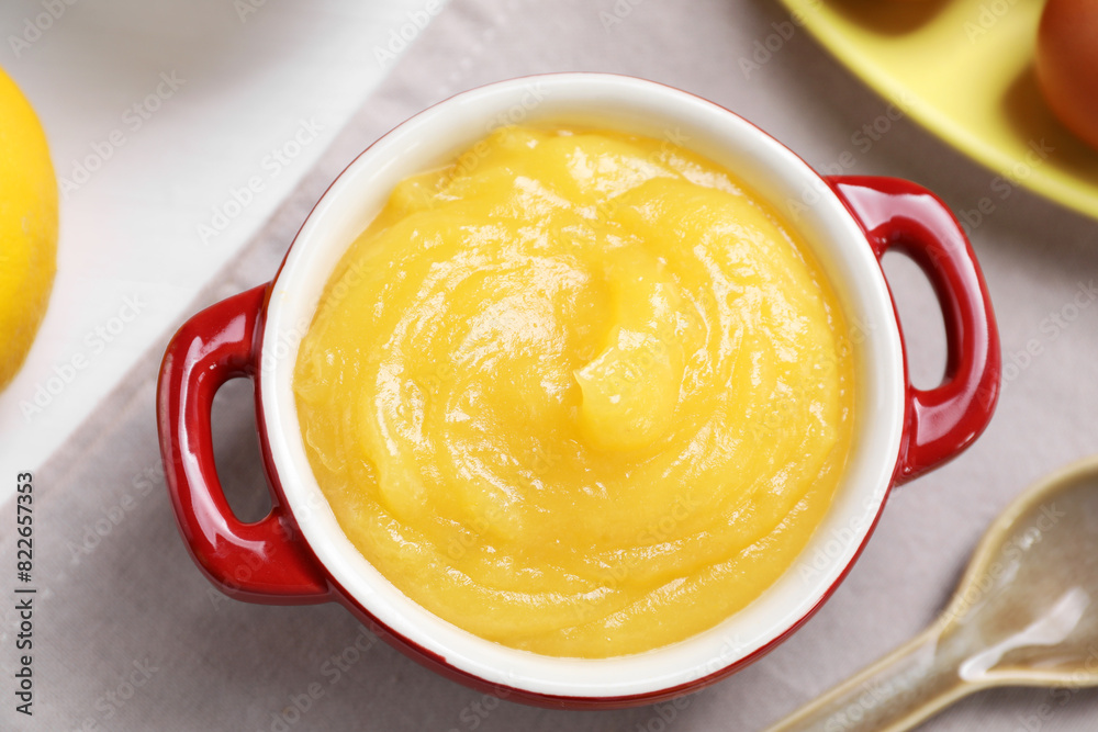 Delicious lemon curd in bowl and spoon on table, flat lay Delicious lemon curd in bowl and spoon on table, flat lay