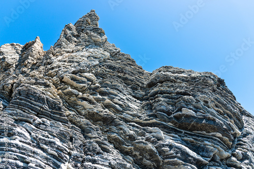 Nature force compressed prominent cracked rock layers structure formation details, in various shapes, colors, thicknesses, at south central coast of Crete, Greece. Nature Geological science concept. photo