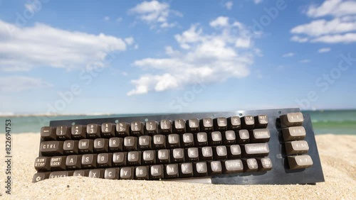 keyboard stcuk in sand on beach photo