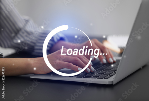 Loading. Woman working on laptop at table indoors, closeup photo