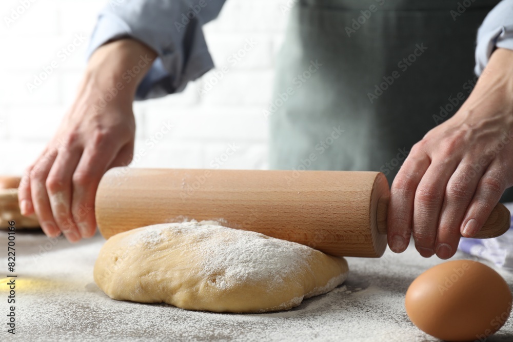 Woman rolling raw dough at table, closeup Woman rolling raw dough at table, closeup