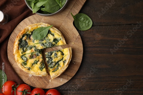 Delicious pie with spinach on wooden table, flat lay. Space for text