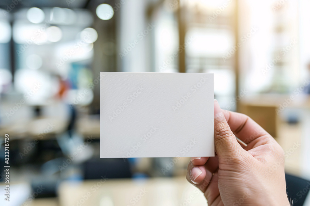 Blank business card held by a person with an office background Blank business card held by a person with an office background