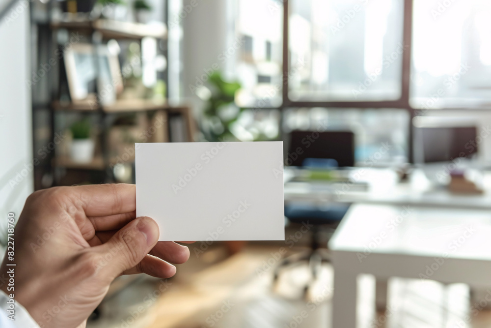 Blank business card held by a person with an office background Blank business card held by a person with an office background