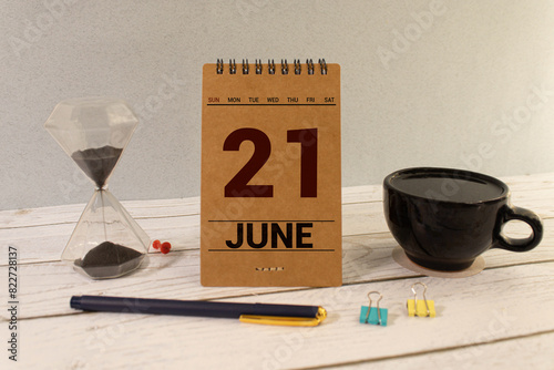 June 21 calendar date text on wooden blocks with blurred nature background.