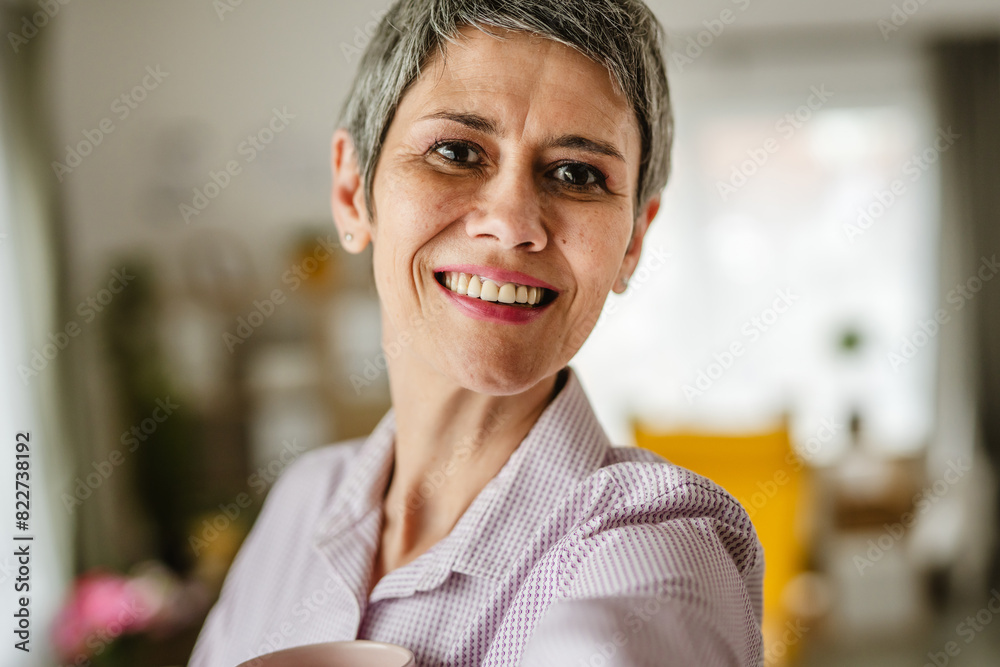 Self portrait of mature woman stand and hold cup of coffee at home Self portrait of mature woman stand and hold cup of coffee at home